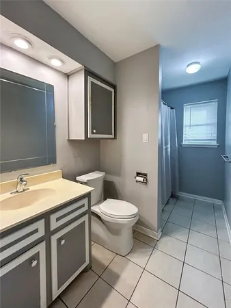 a bathroom with a granite countertop sink toilet and mirror