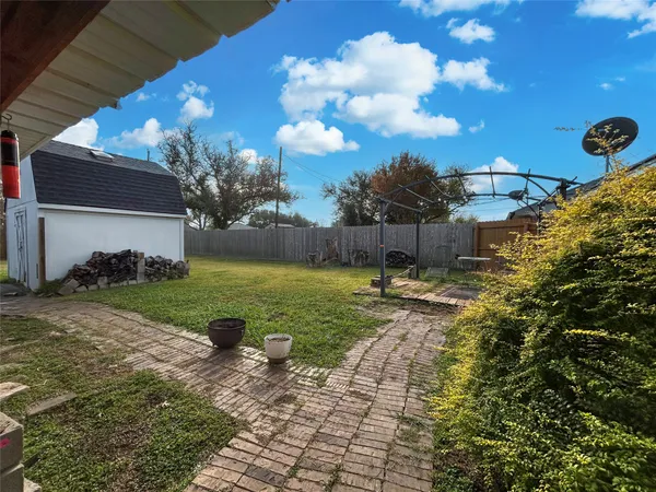 a view of a yard with plants and a fountain