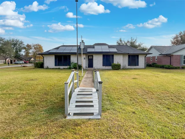 a front view of a house with swimming pool and porch with furniture