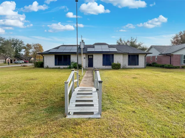 a front view of a house with swimming pool and porch with furniture