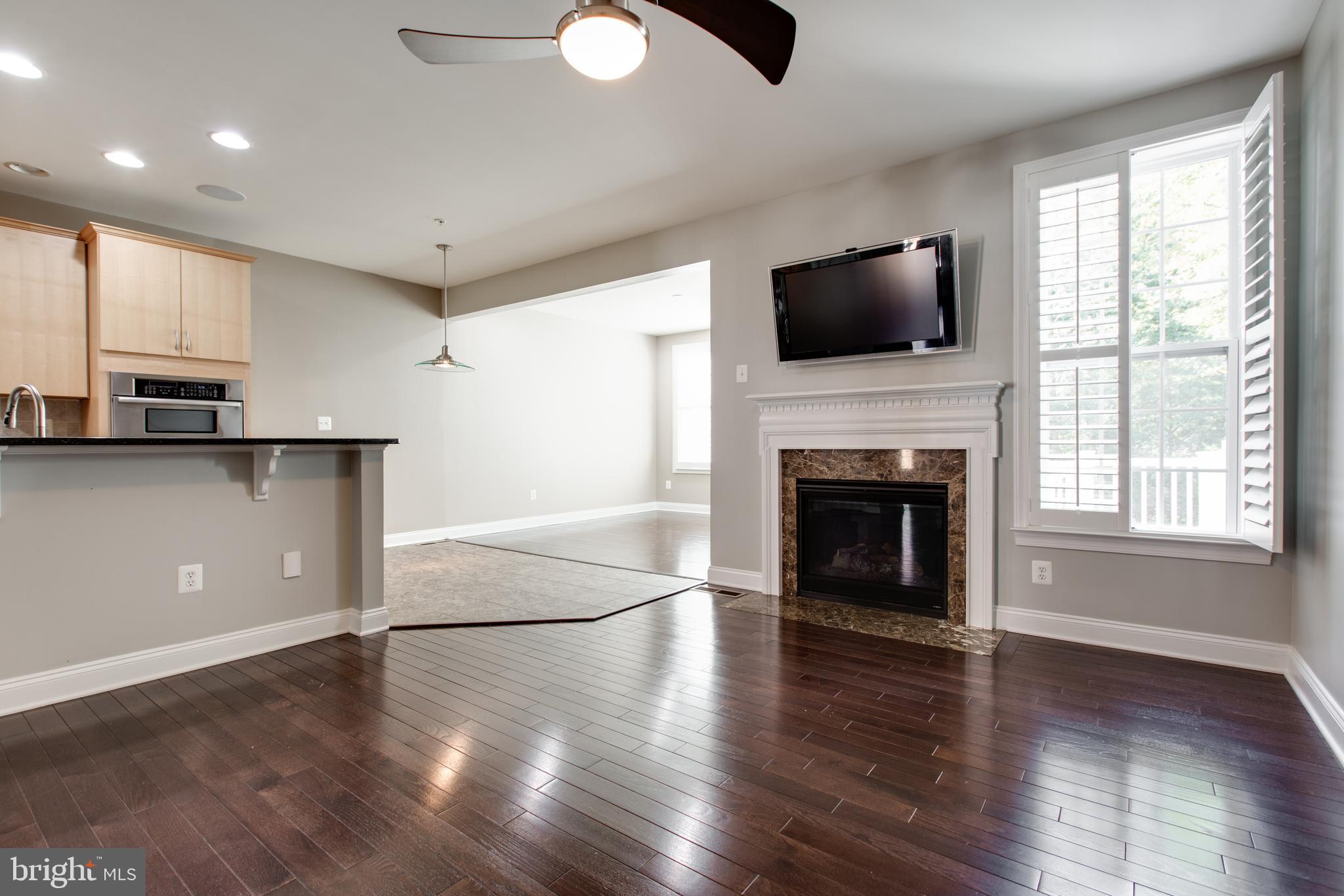 2265 Brimstone Place Hanover, MD 21076 - Photo 16 of 70 an empty room with windows fireplace and wooden floor