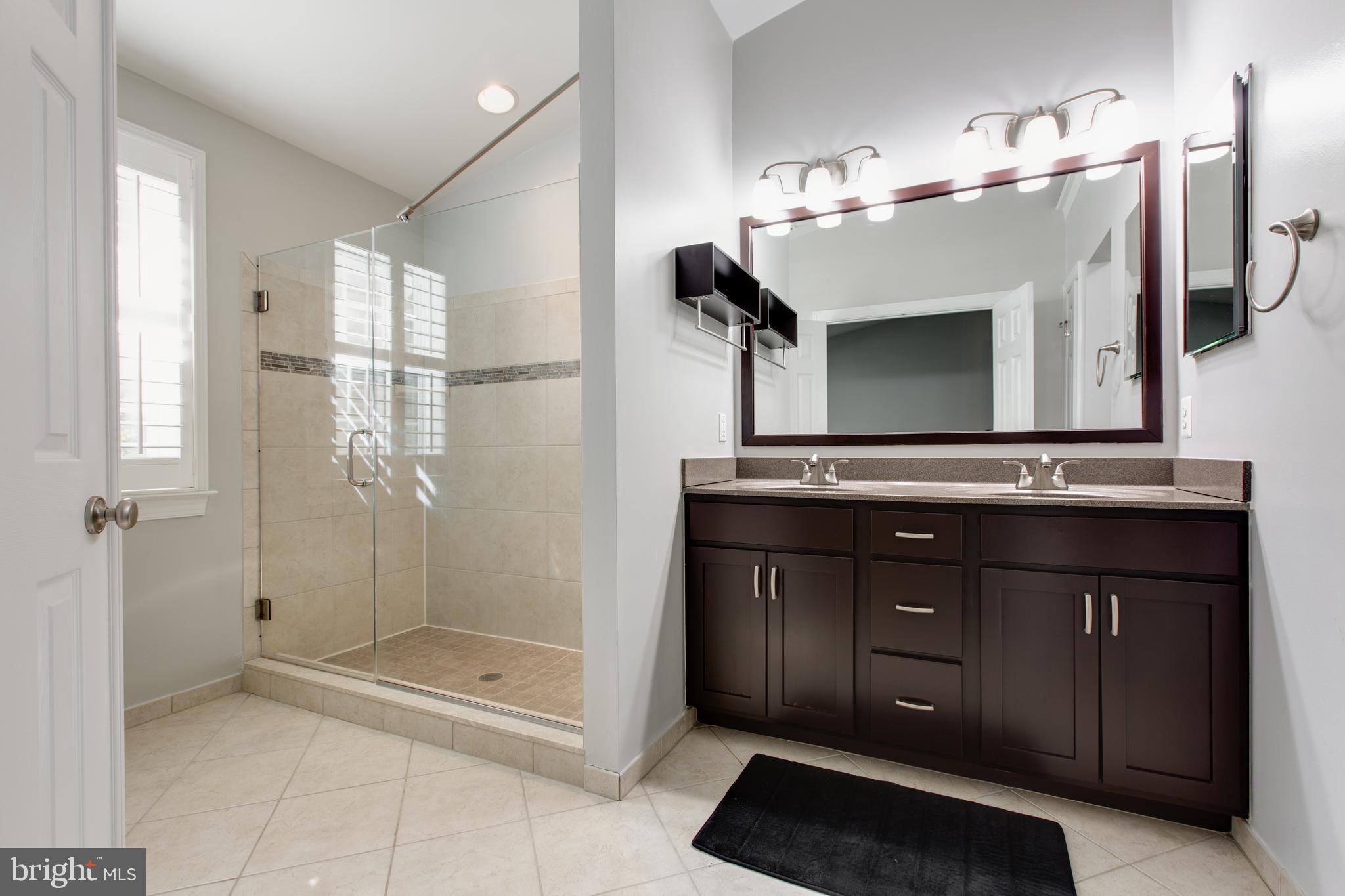 2265 Brimstone Place Hanover, MD 21076 - Photo 33 of 70 a bathroom with a granite countertop sink a mirror and shower