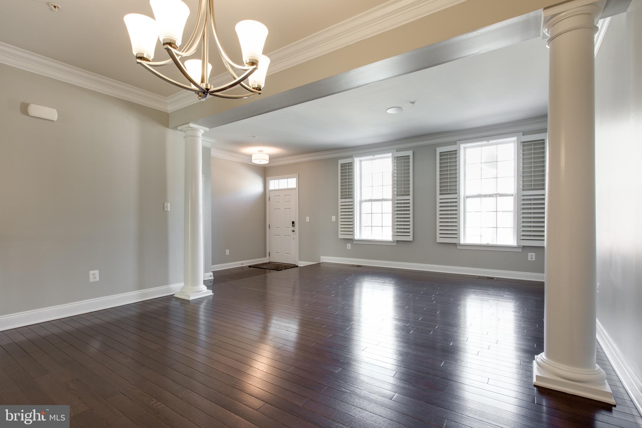 2265 Brimstone Place Hanover, MD 21076 - Photo 9 of 70 a view of an empty room with wooden floor and a window