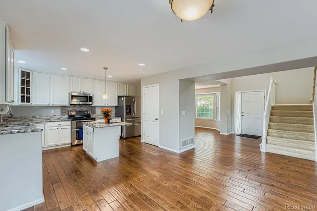 a kitchen with a refrigerator and a stove top oven