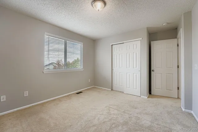 an empty room with windows and closet
