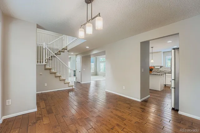 a view of a hallway with wooden floor windows and a kitchen