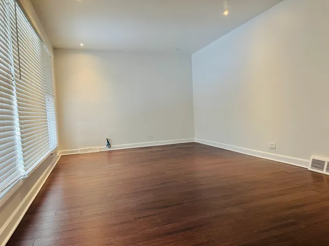 a view of a room with wooden floor and window