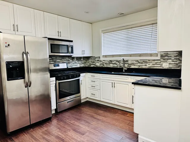 a kitchen with granite countertop white cabinets and white appliances