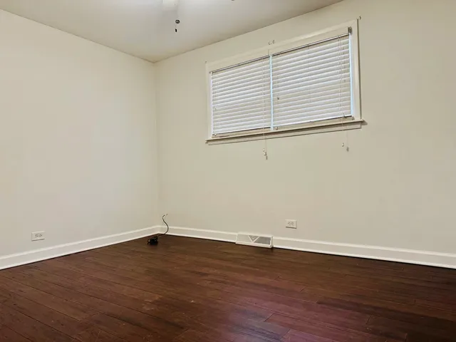 a view of a room that has wooden floor and a window