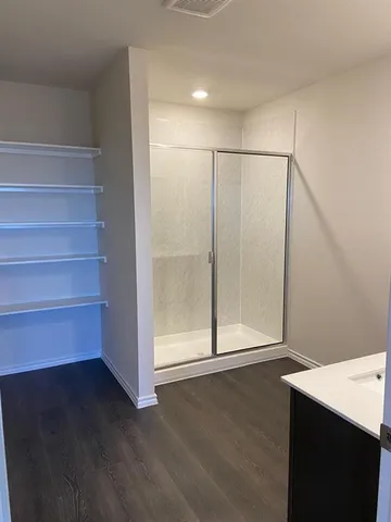 a view of an empty room with wooden floor