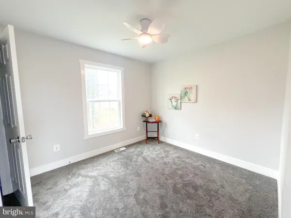 a view of empty room with a ceiling fan and window