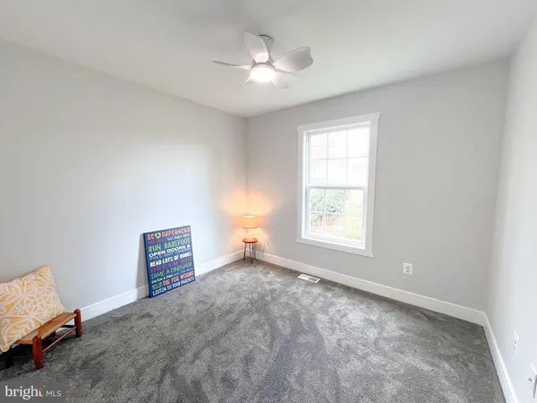 a view of a bedroom with window and ceiling fan