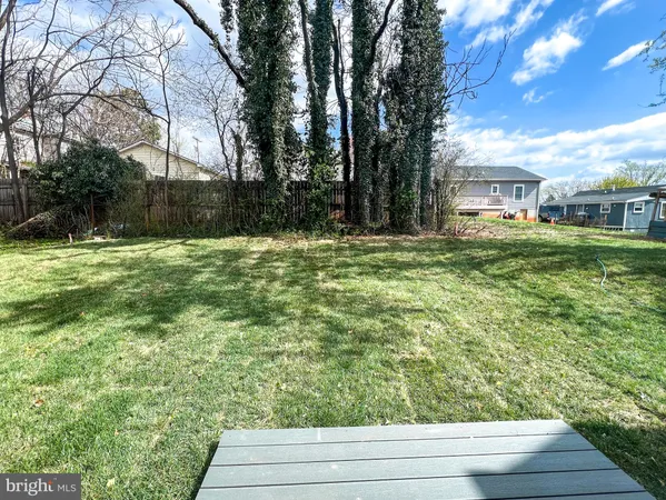 a view of a white house with a yard and large tree