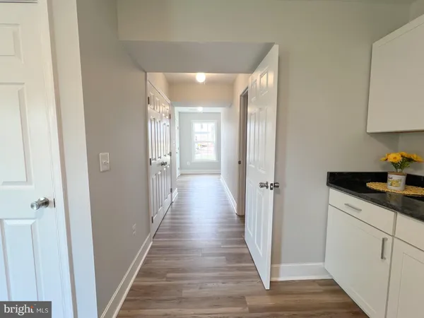 a view of a hallway with wooden floor and staircase