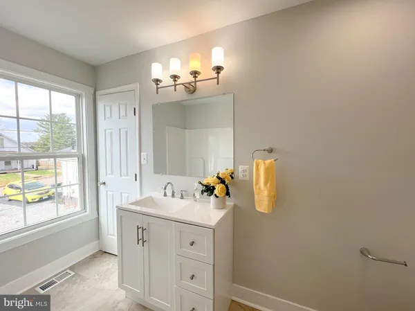 a bathroom with a sink a mirror and window