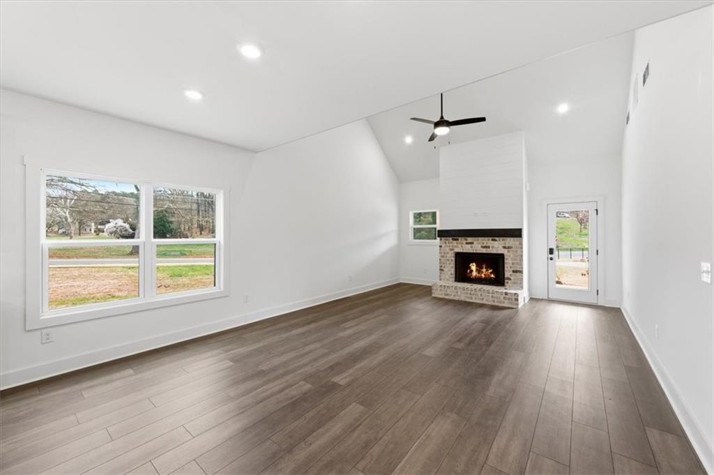 127 Old Alabama Road Southeast Emerson, GA 30137 - Photo 10 of 47 an empty room with wooden floor fireplace and windows