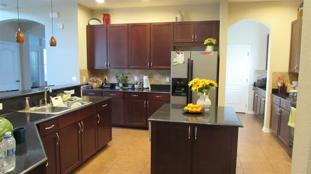 a kitchen with a sink refrigerator and cabinets