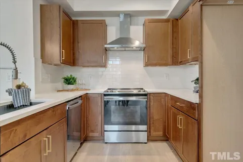 a kitchen with stainless steel appliances granite countertop a stove a sink and a refrigerator