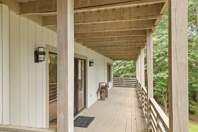 a view of a balcony with wooden floor and fence