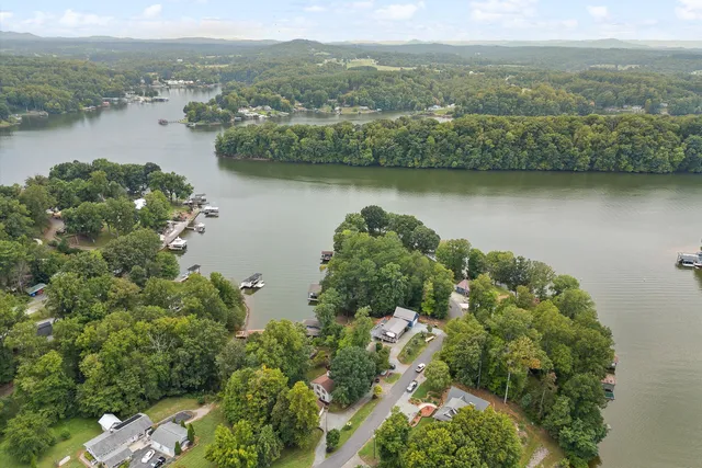 an aerial view of lake residential house with outdoor space and trees around