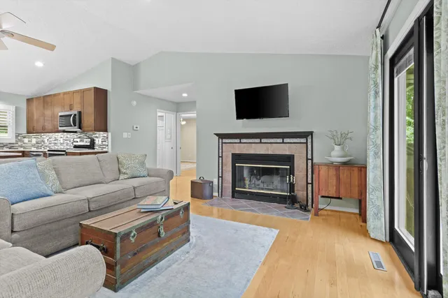 a living room with furniture a flat screen tv and a fireplace