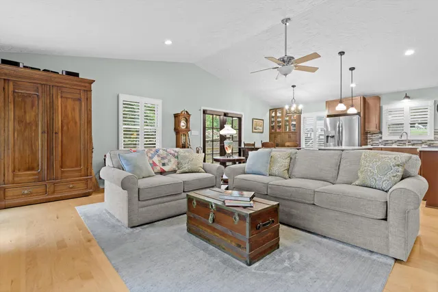a living room with furniture a ceiling fan and a window
