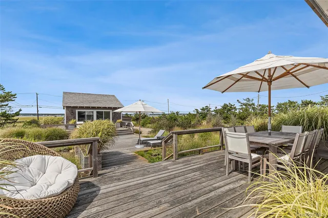 a view of a roof deck with table and chairs under an umbrella