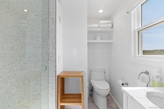 a bathroom with a toilet a sink and mirror