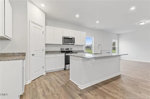 a view of a kitchen with granite countertop stainless steel appliances and wooden floor