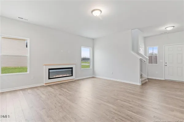 a kitchen with granite countertop a stove top oven a sink and white cabinets with wooden floor