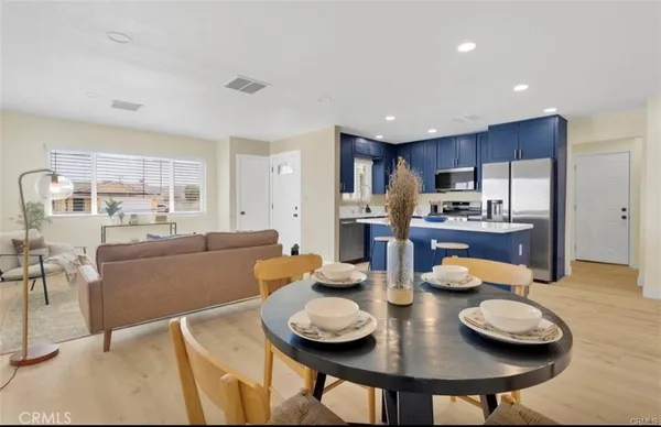 a kitchen with stainless steel appliances wooden floor dining table and chairs