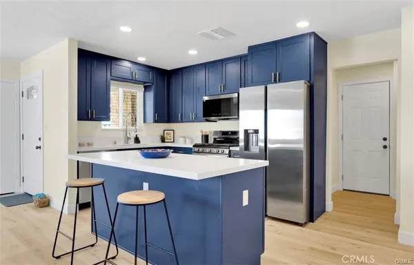 a kitchen with stainless steel appliances a refrigerator and a stove top oven