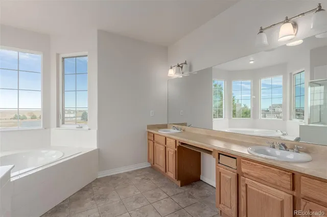 a bathroom with a granite countertop sink and mirror with bathtub
