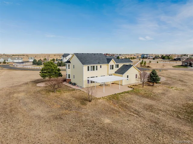 a view of a white house with a big yard and large trees