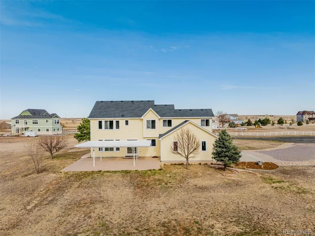 an aerial view of a house with a yard and ocean view