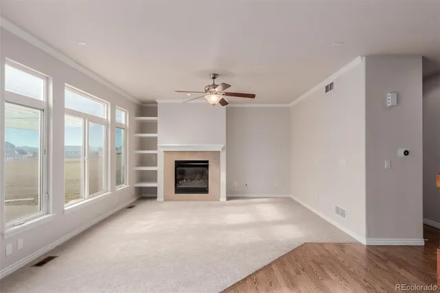 wooden floor fireplace and windows in an empty room