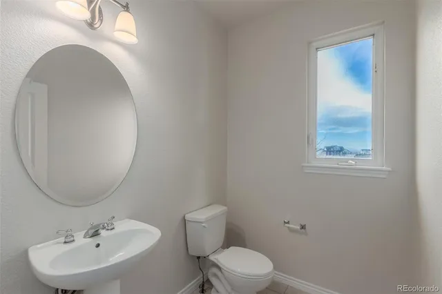 a bathroom with a toilet a sink and mirror