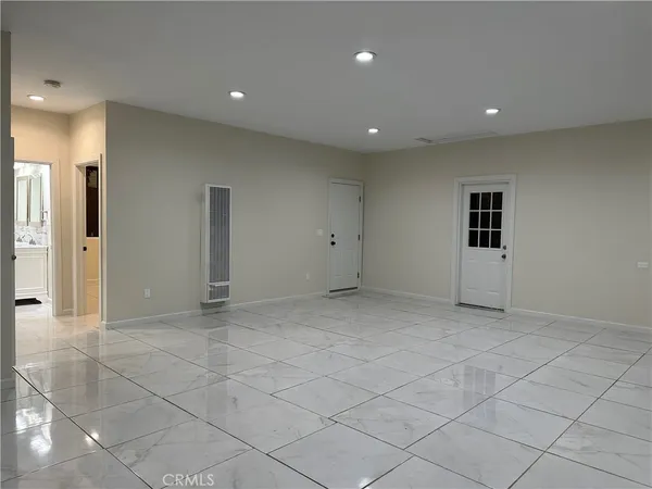 an empty room with kitchen view