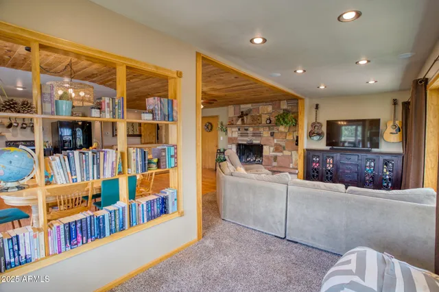 a living room with couches a flat screen tv and a fireplace