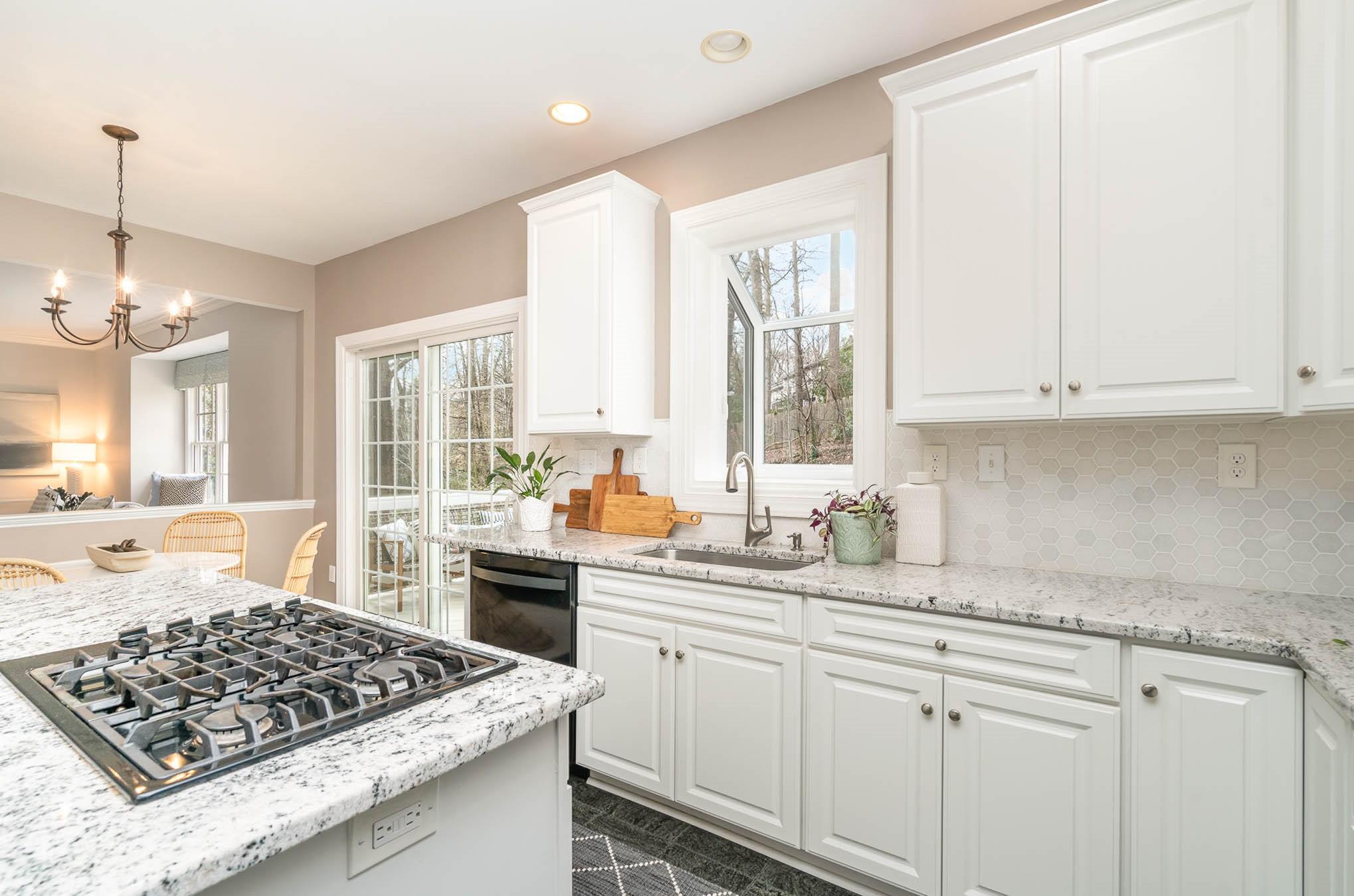3924 Highview Road Charlotte, NC 28210 - Photo 9 of 45 a kitchen with stainless steel appliances granite countertop a sink stove and white cabinets with wooden floor