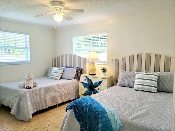 a bedroom with two beds and a chandelier