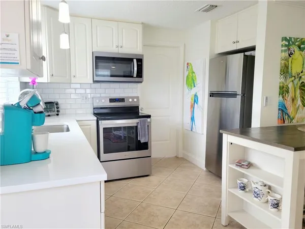 a kitchen with stainless steel appliances a stove a refrigerator and a microwave