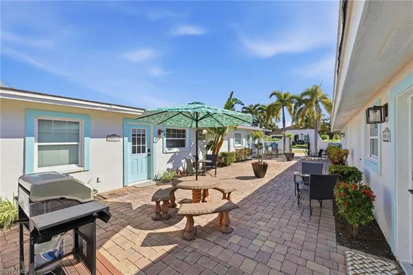 a view of a patio with couches table and chairs and potted plants