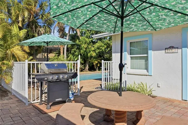 a view of a patio with a table and chairs under an umbrella
