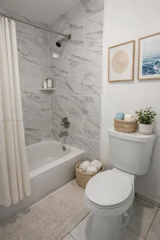 a white toilet sitting next to a bath tub and a shower