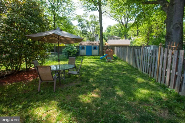 a view of backyard with table and chairs under an umbrella