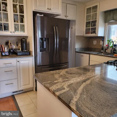 a kitchen with stainless steel appliances granite countertop a refrigerator a stove and a sink with granite countertops