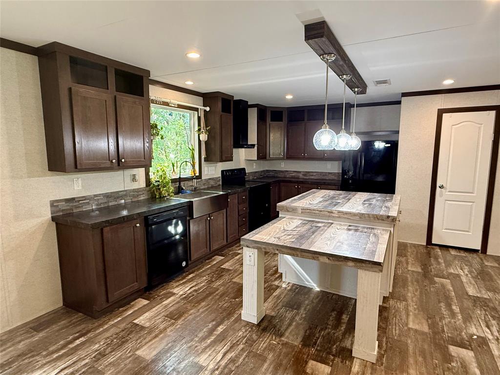 145 Adalida Lane Springtown, TX 76082 - Photo 10 of 29 Modern kitchen featuring a two-tiered island with wood-finish countertop, dark wood cabinetry, and wood-finish flooring