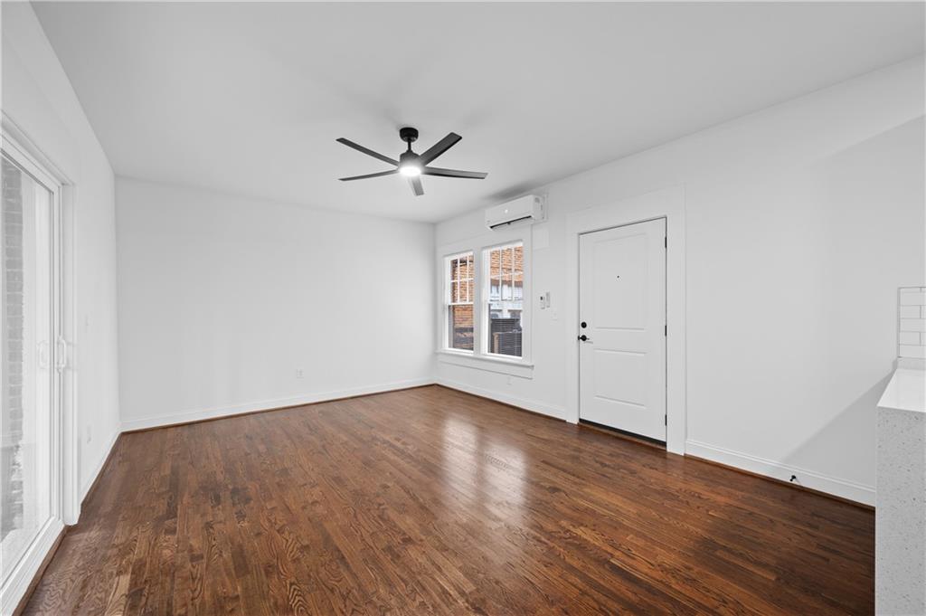 405 4th Street Northeast, Unit 8 Atlanta, GA 30308 - Photo 3 of 12 an empty room with wooden floor and windows
