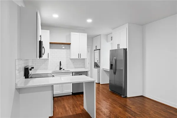 a kitchen with a refrigerator a sink and cabinets